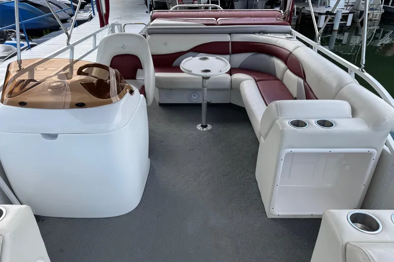 Slide: The Image of 2007 JC SunToon 23TT pontoon boat interior with seating and helm, docked by the water. - 3