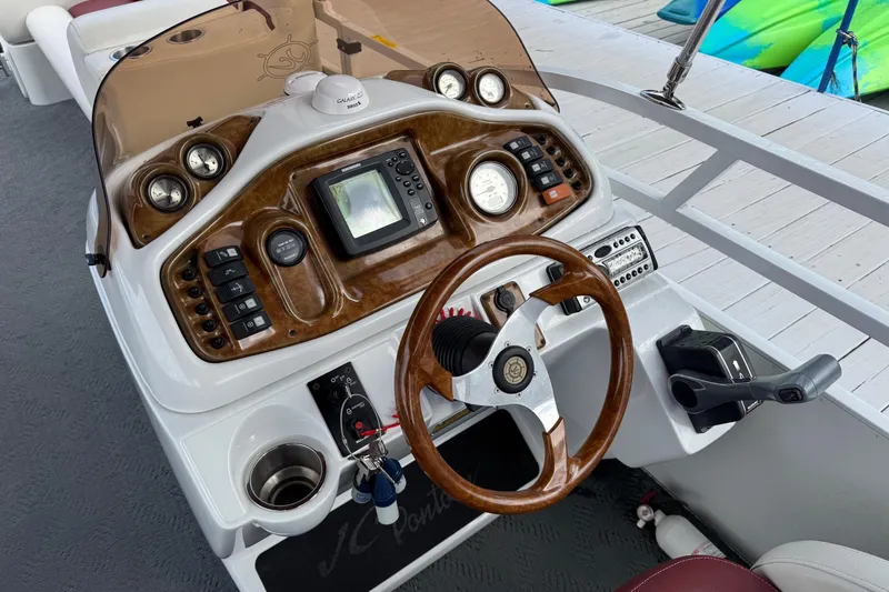 Slide: The Image of Steering console of a 2007 JC SunToon 23TT boat with gauges and controls. - 5