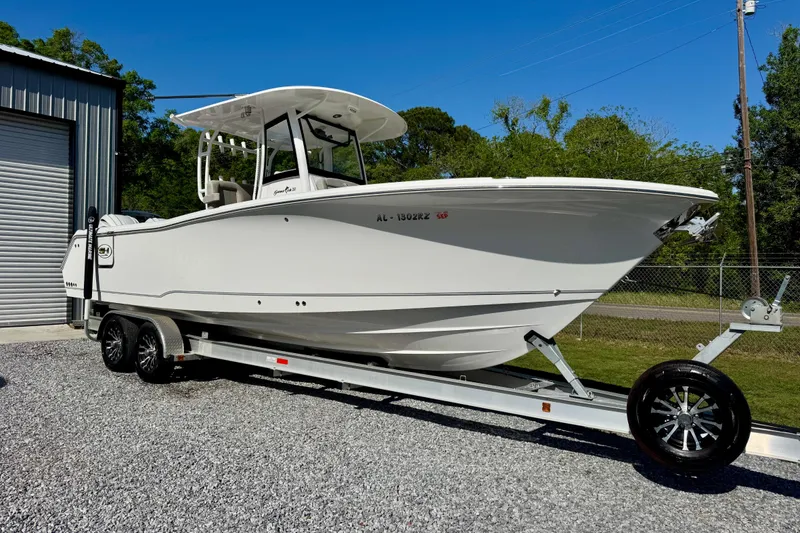 The Image of 2024 Sea Hunt Gamefish 28 Coffin Box boat on trailer, parked outdoors. - 1