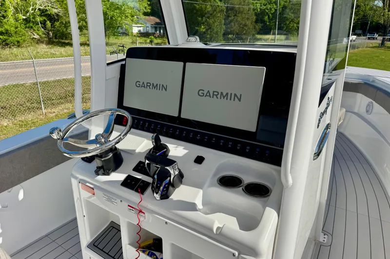 Slide: The Image of 2024 Sea Hunt Gamefish 28 Coffin Box boat console with Garmin displays and steering wheel. - 11
