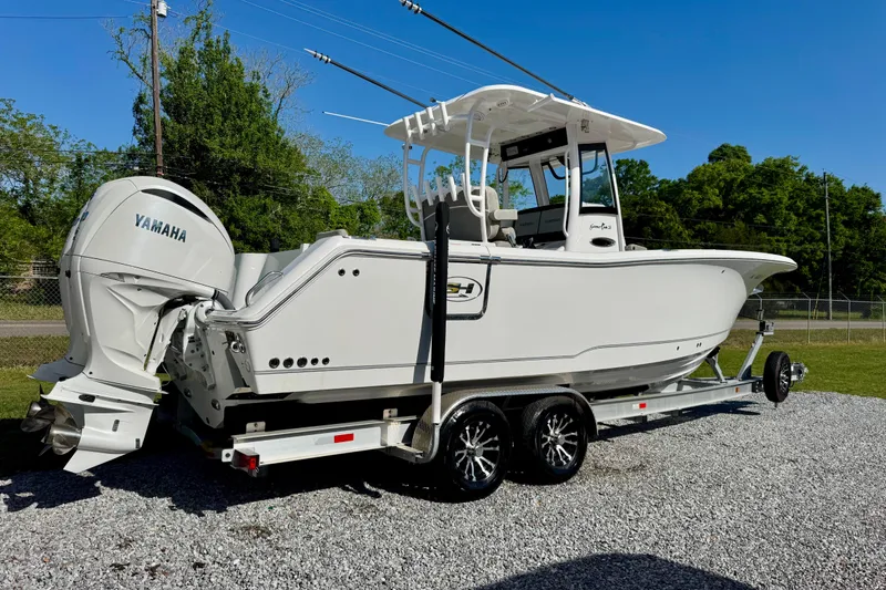 Slide: The Image of 2024 Sea Hunt Gamefish 28 Coffin Box boat on trailer, featuring Yamaha engines. - 3