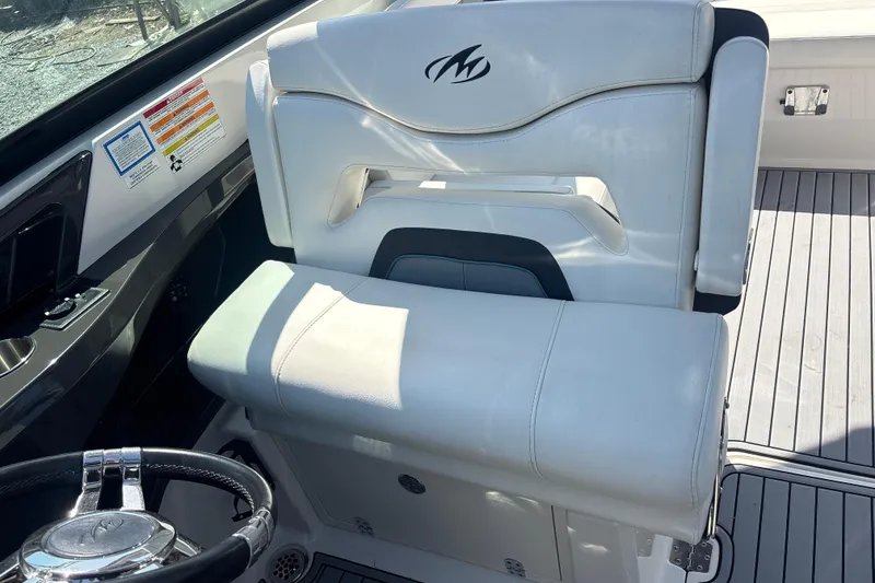 Slide: The Image of Captain's seat of a 2014 Monterey 328SS Super Sport boat, featuring sleek white upholstery. - 15