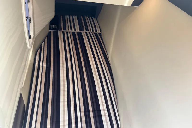 Slide: The Image of 2014 Monterey 328SS Super Sport cabin with striped bedding and porthole window. - 18