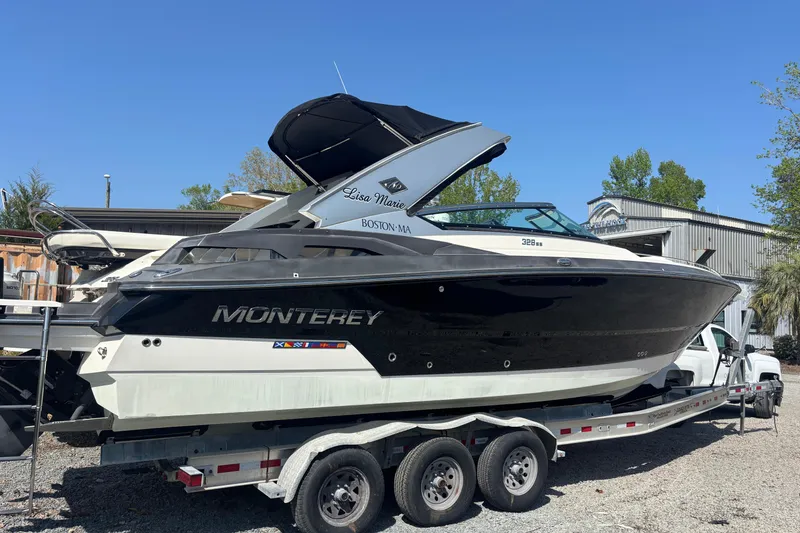 Slide: The Image of 2014 Monterey 328SS Super Sport boat on trailer, black and white design, parked outdoors. - 3