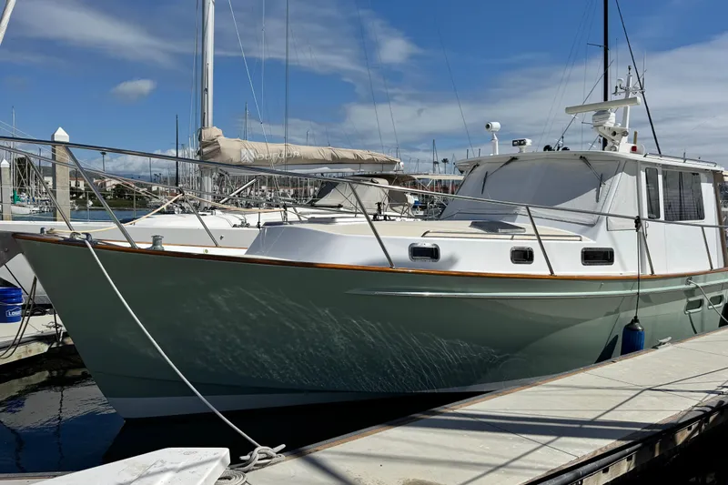 The Image of 1999 Legacy Yachts 40 Express docked at marina under clear blue sky. - 1