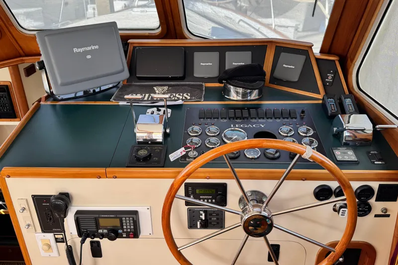 Slide: The Image of 1999 Legacy Yachts 40 Express helm with Raymarine electronics and classic wooden steering wheel. - 10