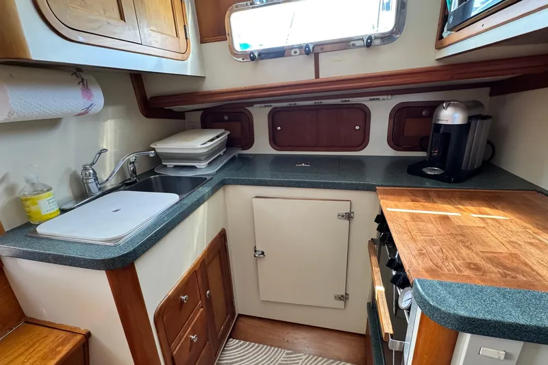 Slide: The Image of 1999 Legacy Yachts 40 Express galley with sink, countertop, and coffee maker. - 14