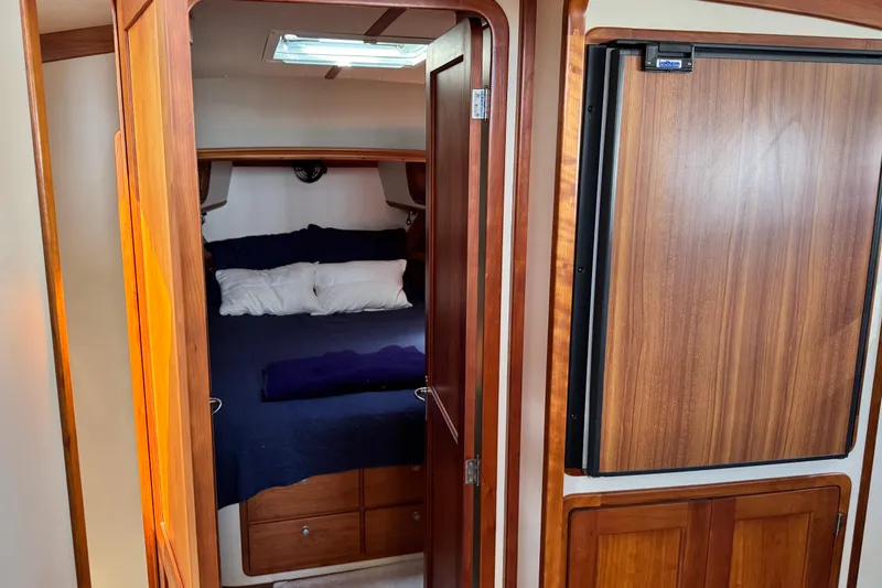 Slide: The Image of Interior cabin of 1999 Legacy Yachts 40 Express with wooden finishes and cozy bedding. - 15