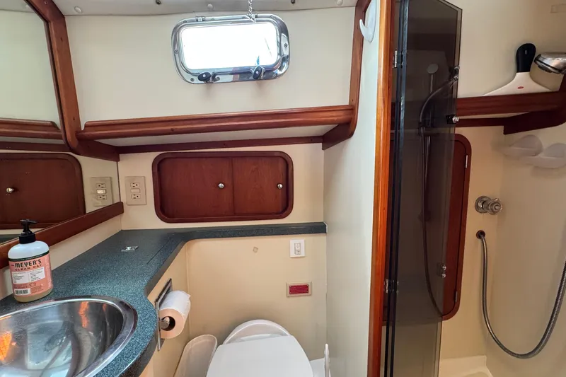 Slide: The Image of Bathroom interior of 1999 Legacy Yachts 40 Express with sink, shower, and storage cabinets. - 16