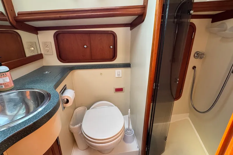 Slide: The Image of Bathroom interior of 1999 Legacy Yachts 40 Express, featuring sink, toilet, and shower. - 17