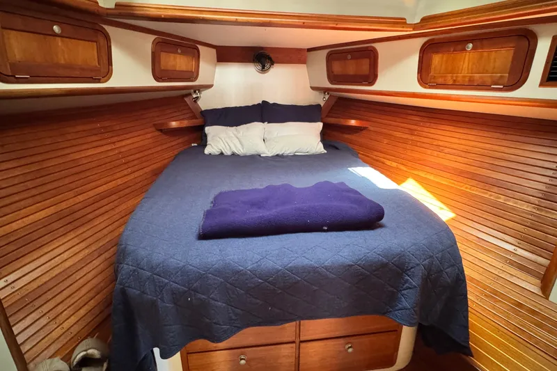 Slide: The Image of Cozy cabin interior of 1999 Legacy Yachts 40 Express with wooden paneling and blue bedding. - 18