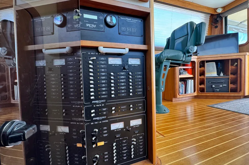 Slide: The Image of Electrical panel and seating area inside a 1999 Legacy Yachts 40 Express boat. - 19