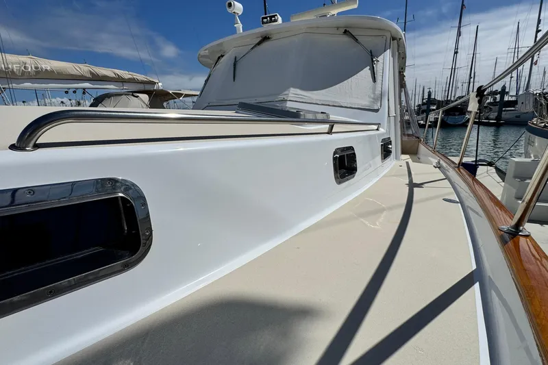 Slide: The Image of 1999 Legacy Yachts 40 Express, sleek deck view in marina setting. - 2