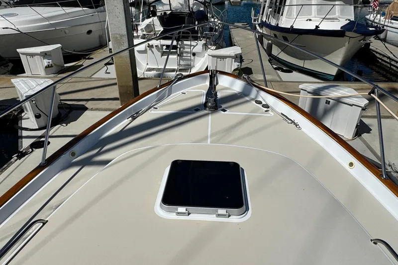 Slide: The Image of 1999 Legacy Yachts 40 Express docked, showcasing sleek deck design and marina surroundings. - 23