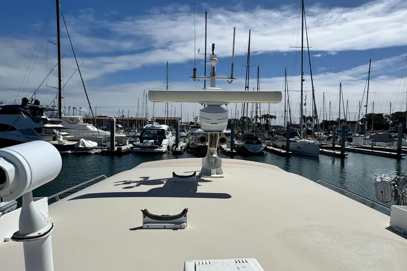 Slide: The Image of 1999 Legacy Yachts 40 Express docked in a marina, surrounded by sailboats. - 24