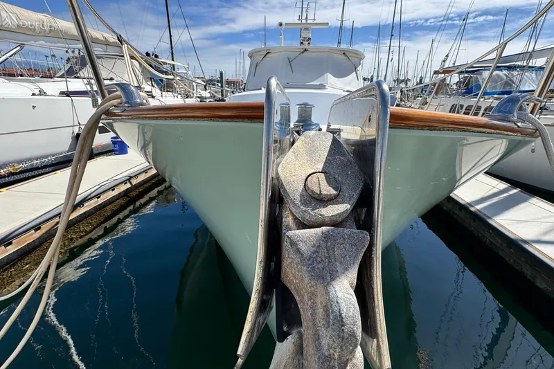 Slide: The Image of 1999 Legacy Yachts 40 Express docked, showcasing anchor and sleek hull design. - 26