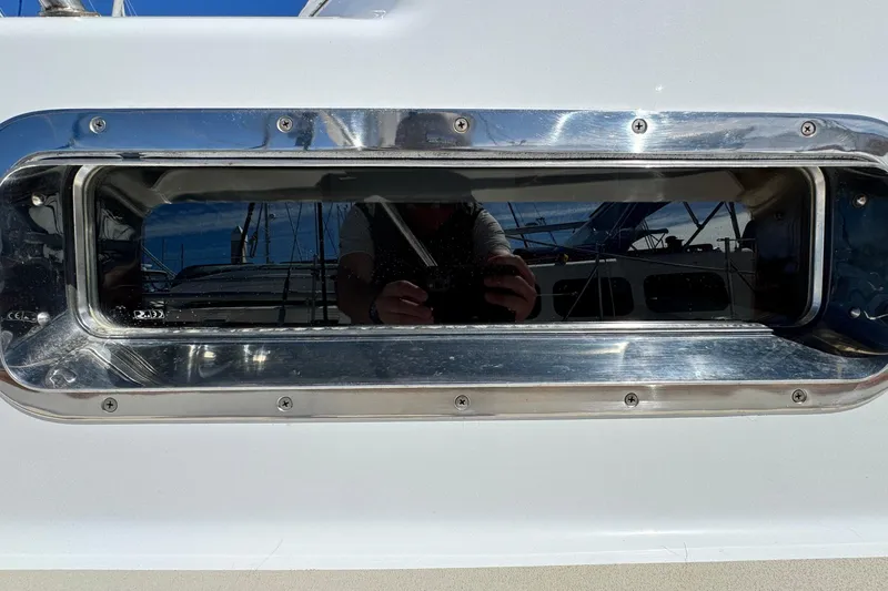 Slide: The Image of Close-up of a 1999 Legacy Yachts 40 Express porthole with reflective chrome finish. - 3