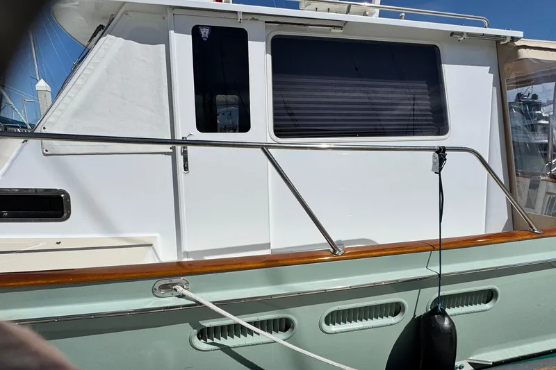 Slide: The Image of Side view of a 1999 Legacy Yachts 40 Express, showcasing sleek design and railing. - 4