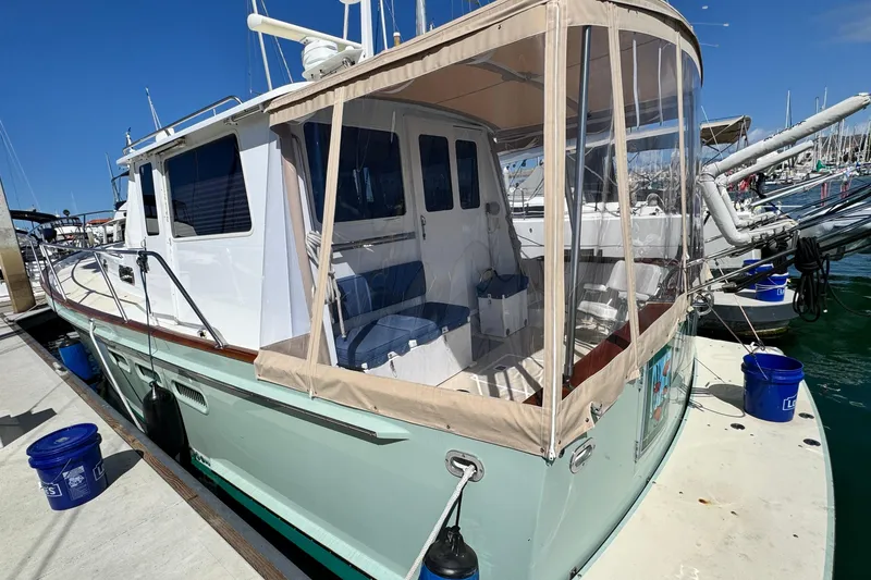 Slide: The Image of 1999 Legacy Yachts 40 Express docked, featuring a covered seating area and sleek design. - 5