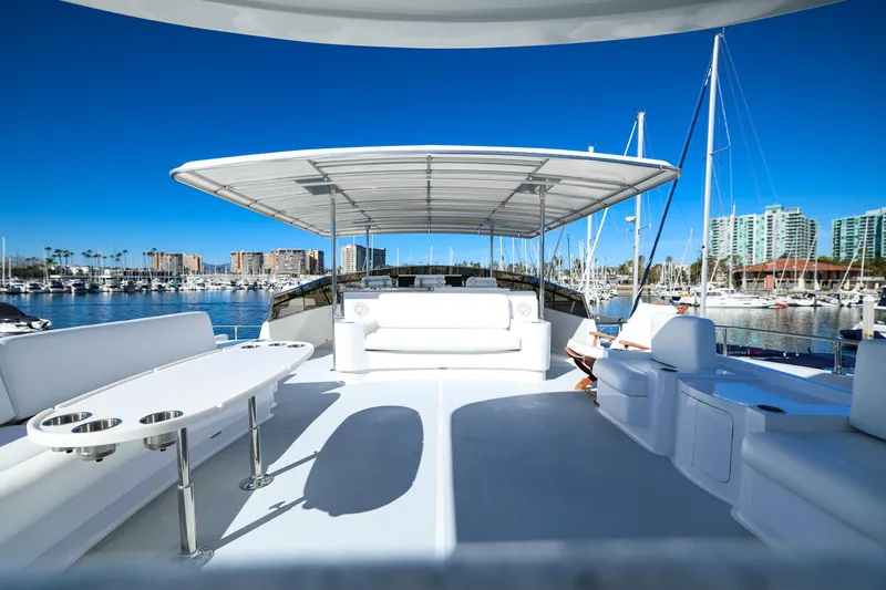 Slide: The Image of Luxurious 1996 Monte Fino Eurostyle yacht deck with seating, marina view, and clear blue sky. - 3