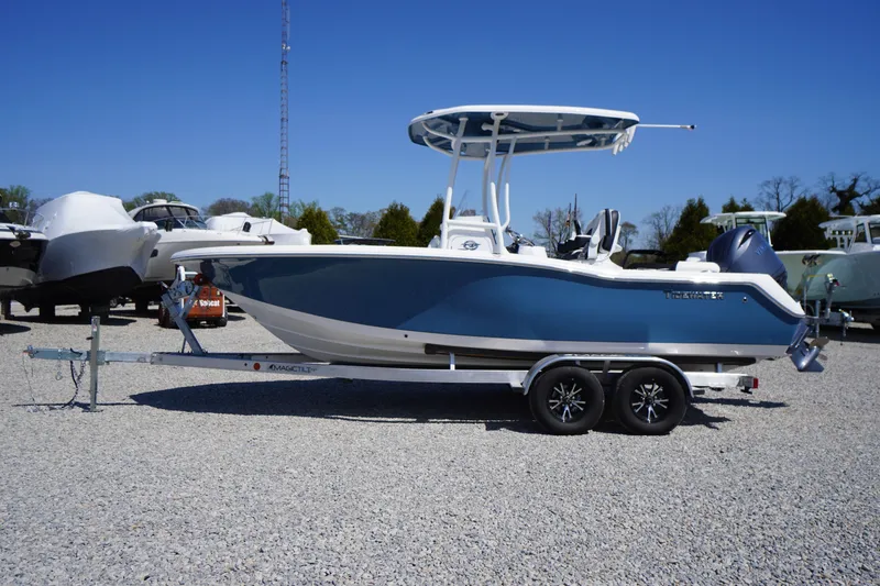 The Image of 2025 Tidewater 210 LXF boat on trailer, blue hull, parked on gravel lot. - 0