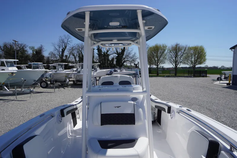 Slide: The Image of 2025 Tidewater 210 LXF boat with T-top, parked in a gravel lot under clear blue sky. - 13