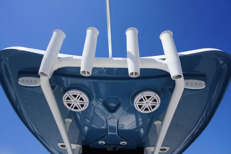 Slide: The Image of 2025 Tidewater 210 LXF boat underside with rod holders and speakers against blue sky. - 15