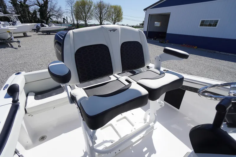 Slide: The Image of 2025 Tidewater 210 LXF boat interior with dual cushioned seats and armrests. - 30