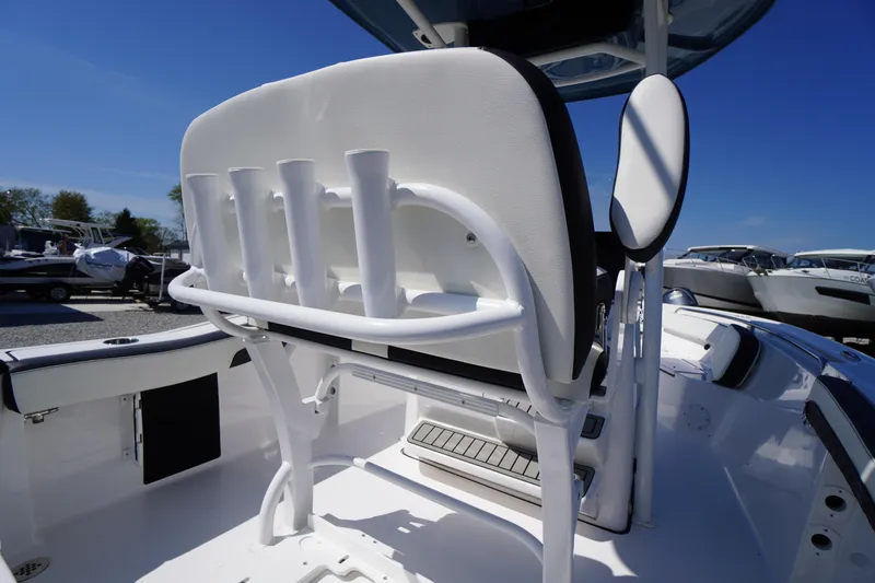 Slide: The Image of 2025 Tidewater 210 LXF boat interior with rod holders and seating, under clear blue sky. - 33