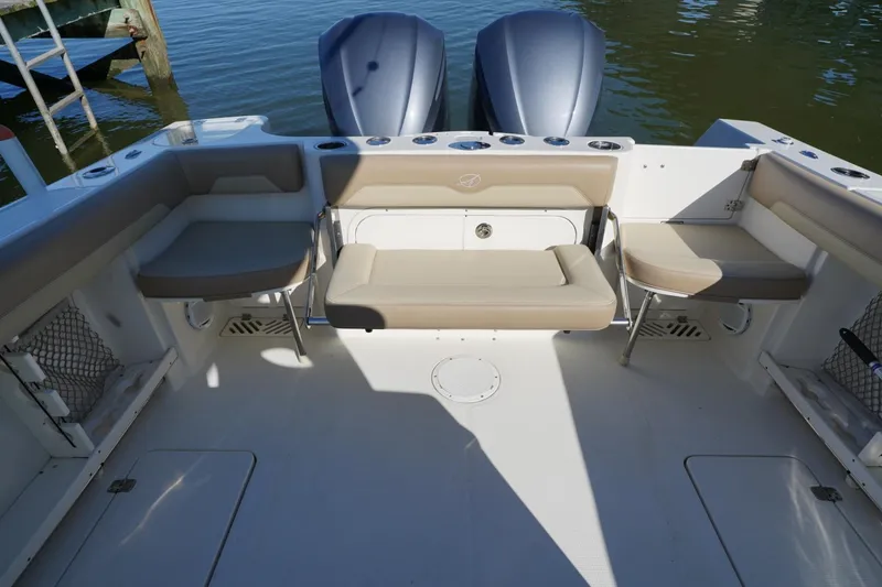Slide: The Image of 2018 Sailfish 290 CC boat interior with seating and twin outboard motors. - 10