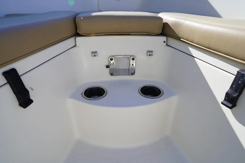 Slide: The Image of 2018 Sailfish 290 CC boat interior with cushioned seating and cup holders. - 12