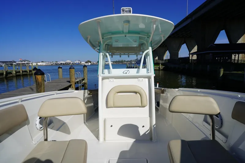 Slide: The Image of 2018 Sailfish 290 CC boat interior with seating, dock, and bridge in background. - 13