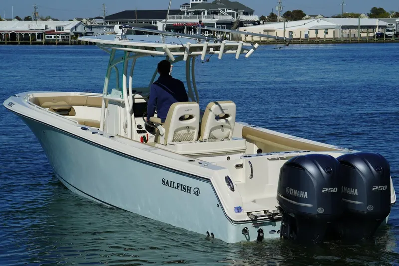Slide: The Image of 2018 Sailfish 290 CC boat with dual Yamaha 250 engines on calm water. - 2