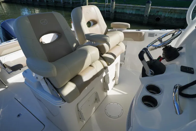 Slide: The Image of 2018 Sailfish 290 CC boat cockpit with dual helm seats and steering wheel. - 4