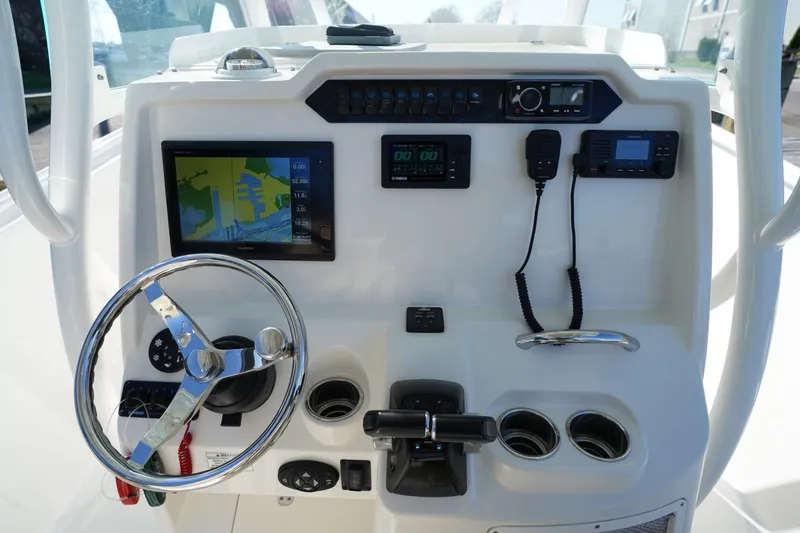 Slide: The Image of 2018 Sailfish 290 CC boat dashboard with steering wheel, navigation screen, and controls. - 7