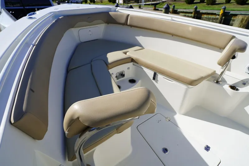 Slide: The Image of 2018 Sailfish 290 CC boat interior with beige cushioned seating and storage compartments. - 8