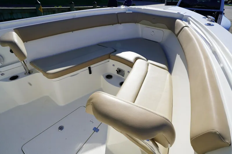 Slide: The Image of 2018 Sailfish 290 CC boat interior with beige seating and cup holders. - 9
