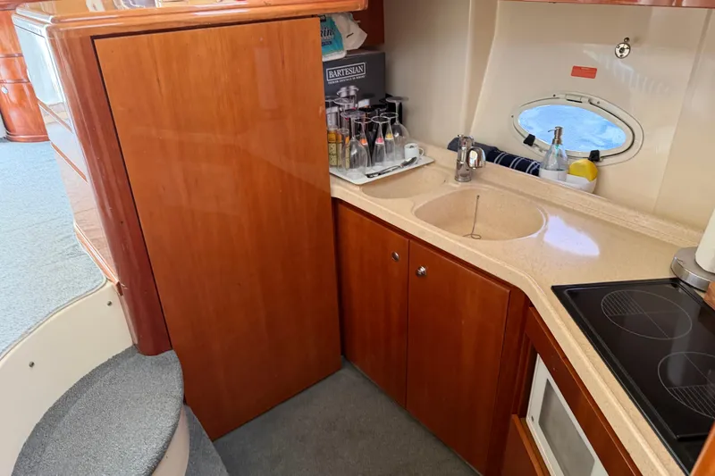 Slide: The Image of Luxurious 2004 Azimut 39E yacht kitchen with wooden cabinetry and modern amenities. - 12