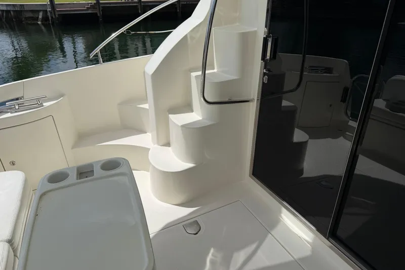 Slide: The Image of Staircase and seating area on 2004 Azimut 39E yacht deck, near water. - 19