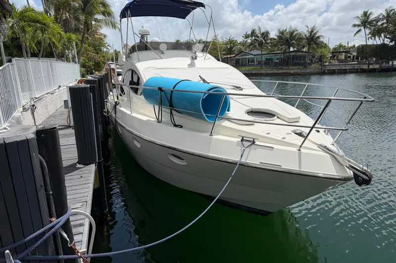 Slide: The Image of 2004 Azimut 39E yacht docked by palm trees under a cloudy sky. - 21