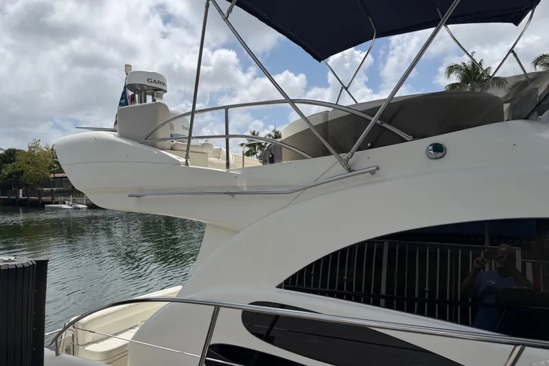 Slide: The Image of 2004 Azimut 39E yacht docked by the water, featuring sleek design and upper deck. - 4