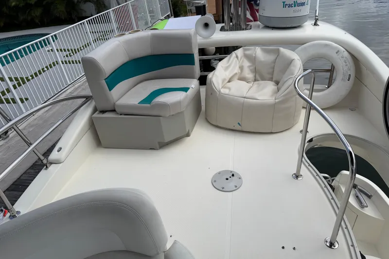 Slide: The Image of 2004 Azimut 39E yacht deck with seating, railing, and life preserver by the water. - 5