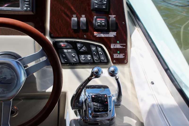 Slide: The Image of Control panel of a 2011 Sea Ray Sundancer 350 boat, featuring steering wheel and throttle levers. - 17