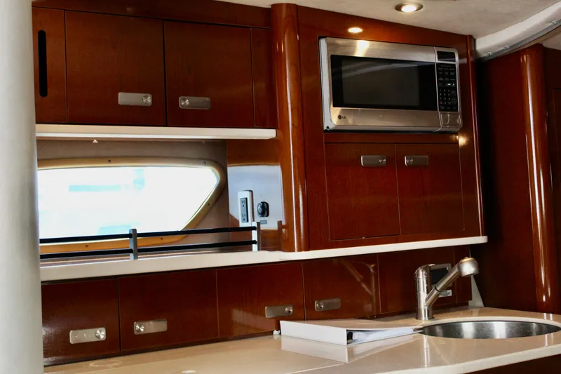 Slide: The Image of Interior of 2011 Sea Ray Sundancer 350 yacht kitchen with wood cabinets and stainless steel appliances. - 25