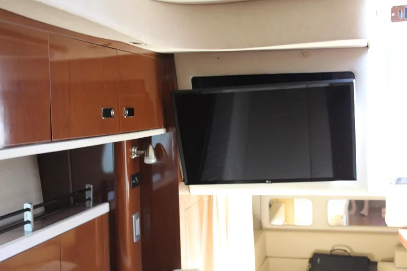 Slide: The Image of Interior of 2011 Sea Ray Sundancer 350 with mounted TV and wooden cabinetry. - 29