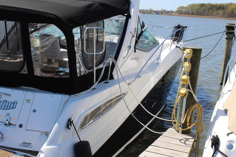 Slide: The Image of 2011 Sea Ray Sundancer 350 docked, featuring sleek design and black canopy. - 4
