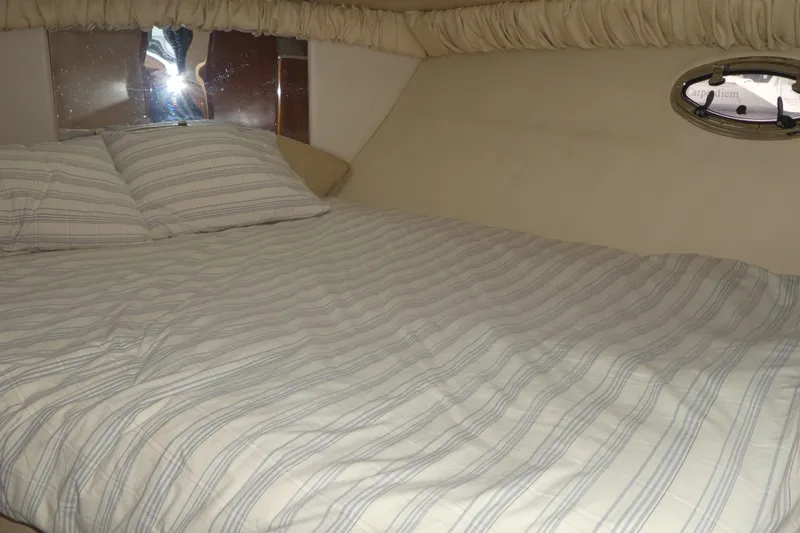 Slide: The Image of Interior cabin of 2003 Meridian 341 Sedan with striped bedding and porthole window. - 13