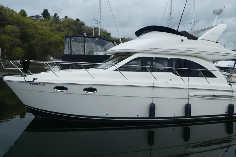 Slide: The Image of 2003 Meridian 341 Sedan yacht docked in a serene marina setting. - 21
