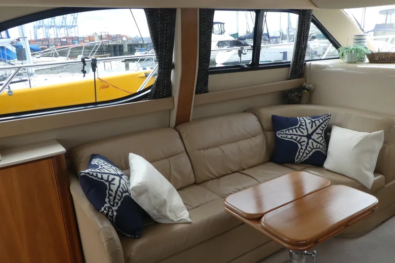 Slide: The Image of Interior of 2003 Meridian 341 Sedan with beige sofa, nautical pillows, and wooden table. - 4