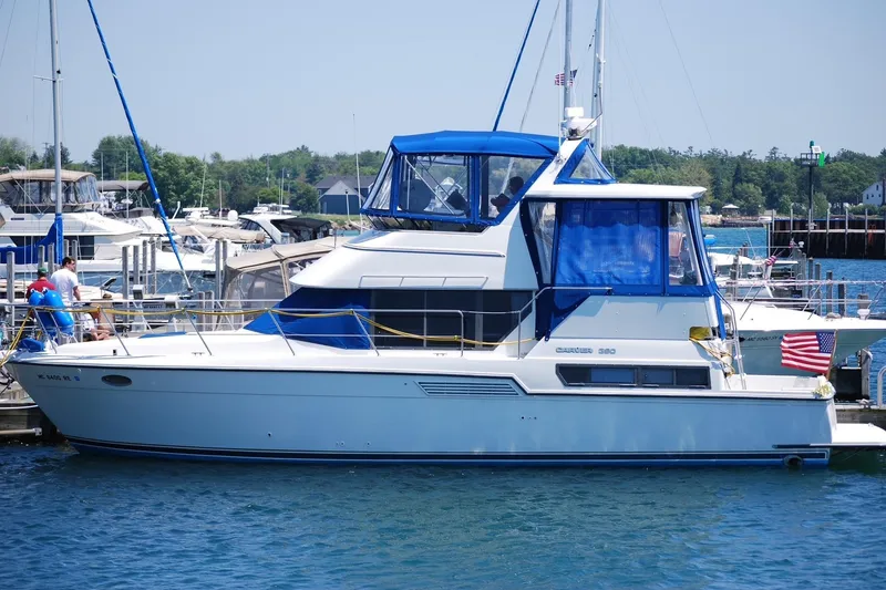The Image of 1994 Carver 390 Cockpit Motor Yacht docked at a marina, featuring blue accents. - 0